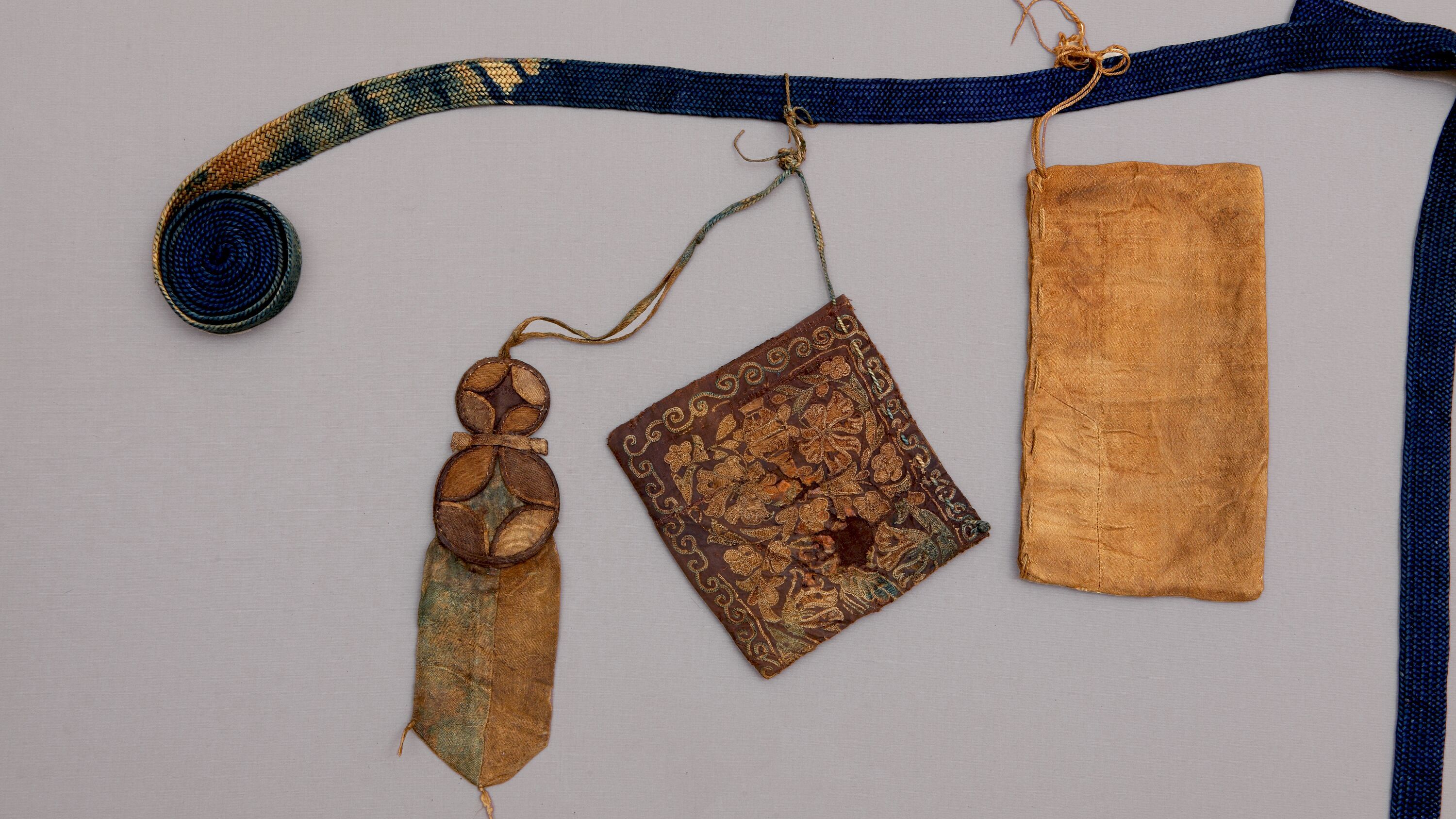 Пояс с подвесными кошельками и амулетом. Империя Юань (1271–1368). Шелковые шнуры, шелк (камка, тафта), шелк с узором золотными нитями (броше на камке). Коллекция Фонда Марджани